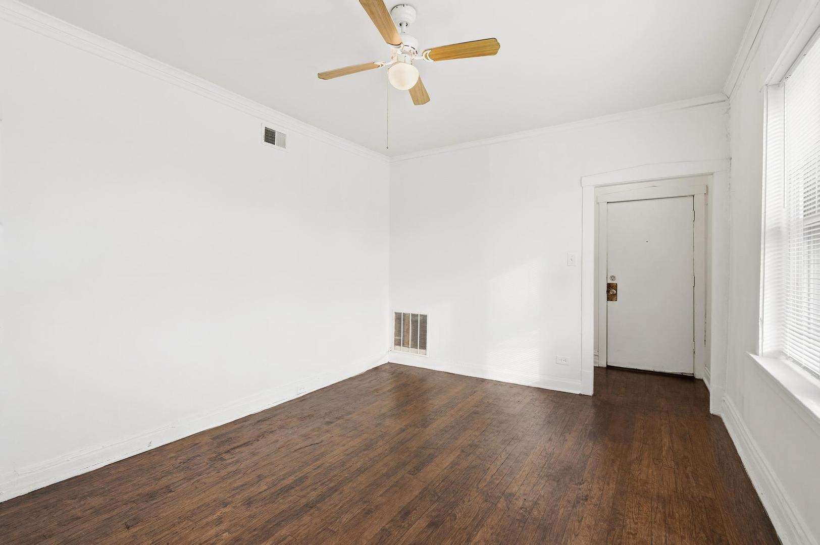 3752 West Division Street, Unit 3W Chicago, IL 60651 - Photo 3 of 11 an empty room with wooden floor and windows