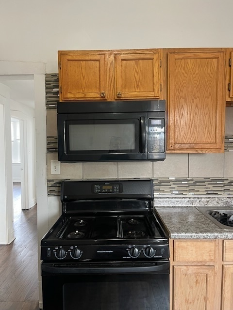 3752 West Division Street, Unit 3W Chicago, IL 60651 - Photo 5 of 11 a kitchen with granite countertop a stove and a microwave