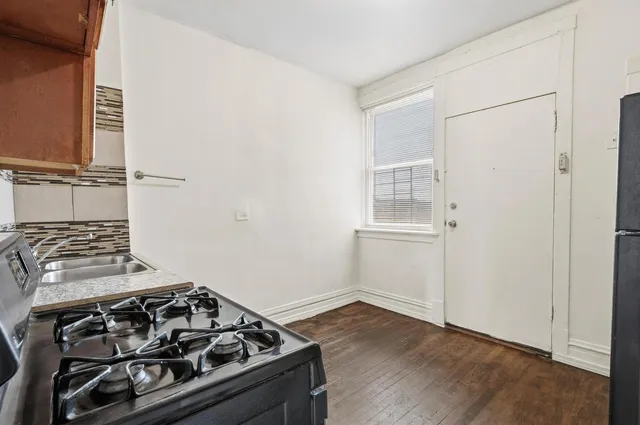 a kitchen with wooden floor and a stove top oven