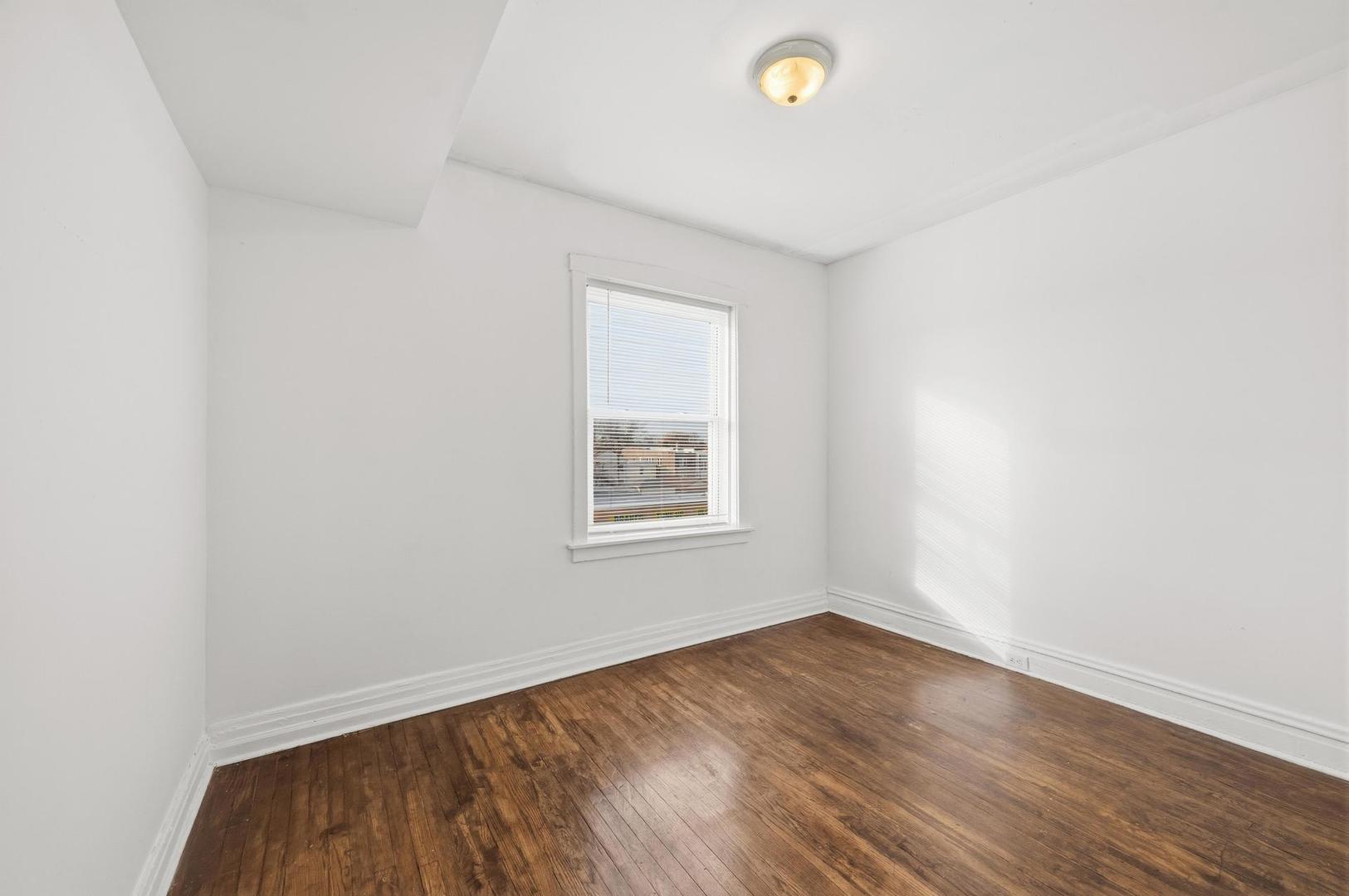 3752 West Division Street, Unit 3W Chicago, IL 60651 - Photo 10 of 11 an empty room with wooden floor and windows