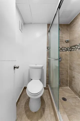 a bathroom with a sink shower and a mirror
