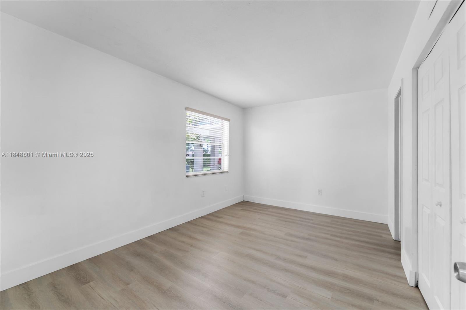 6911 Southwest 129th Avenue, Unit 2 Miami, FL 33183 - Photo 16 of 30 an empty room with wooden floor and windows