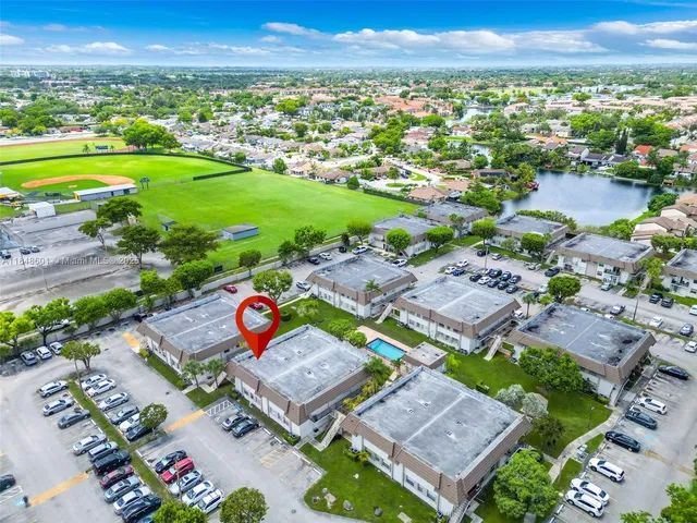 an aerial view of a residential houses with outdoor space and lake view