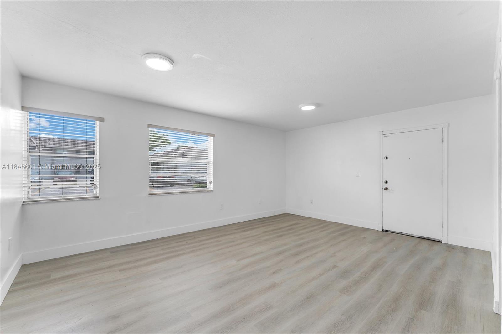 6911 Southwest 129th Avenue, Unit 2 Miami, FL 33183 - Photo 4 of 30 a view of an empty room with wooden floor and a window