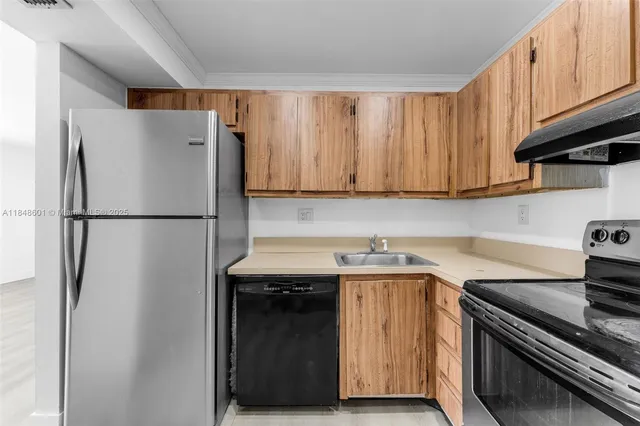 a kitchen with stainless steel appliances granite countertop a refrigerator and a stove top oven