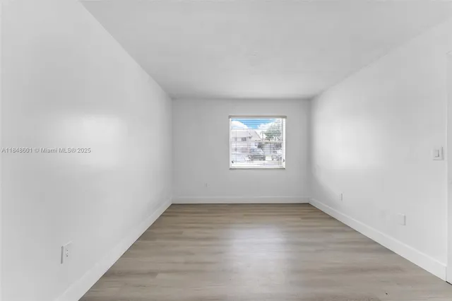 a view of a room with a walk in closet and wooden floor