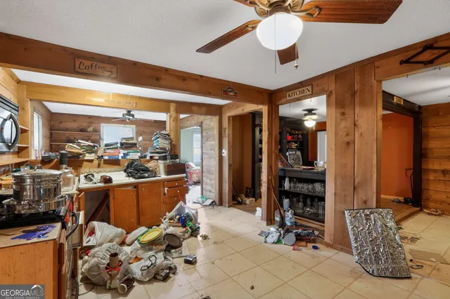 a large living room with stainless steel appliances kitchen island granite countertop furniture a rug and a window