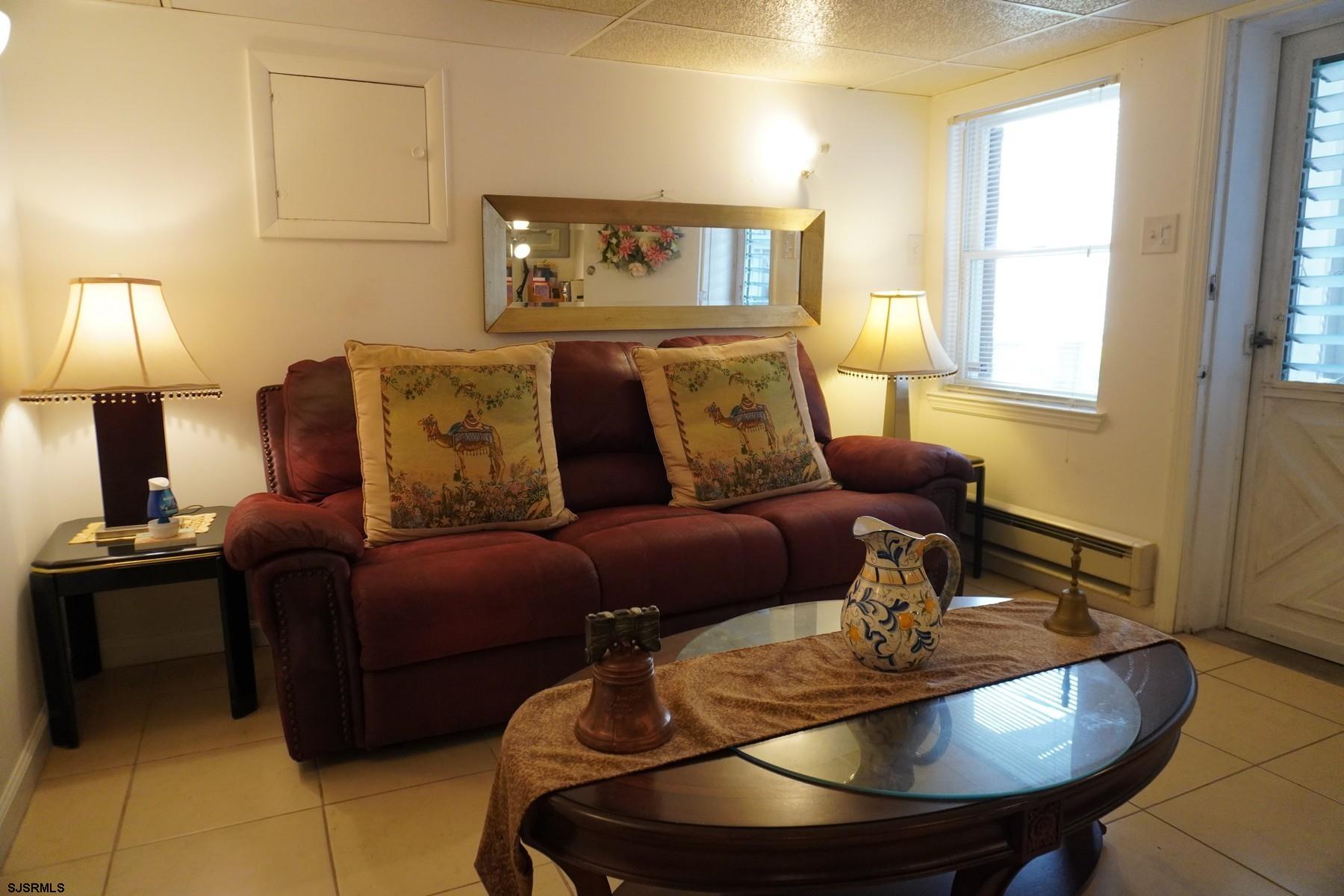4703 Ventnor Avenue, Unit LOWER LEVEL Atlantic City, NJ 08401 - Photo 14 of 22 a living room with furniture a lamp and a dining table