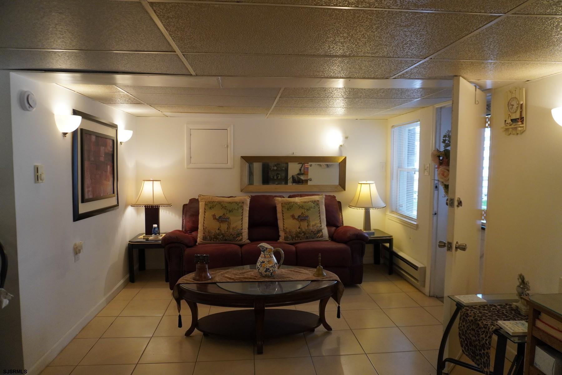 4703 Ventnor Avenue, Unit LOWER LEVEL Atlantic City, NJ 08401 - Photo 15 of 22 a living room with fireplace furniture and a chandelier