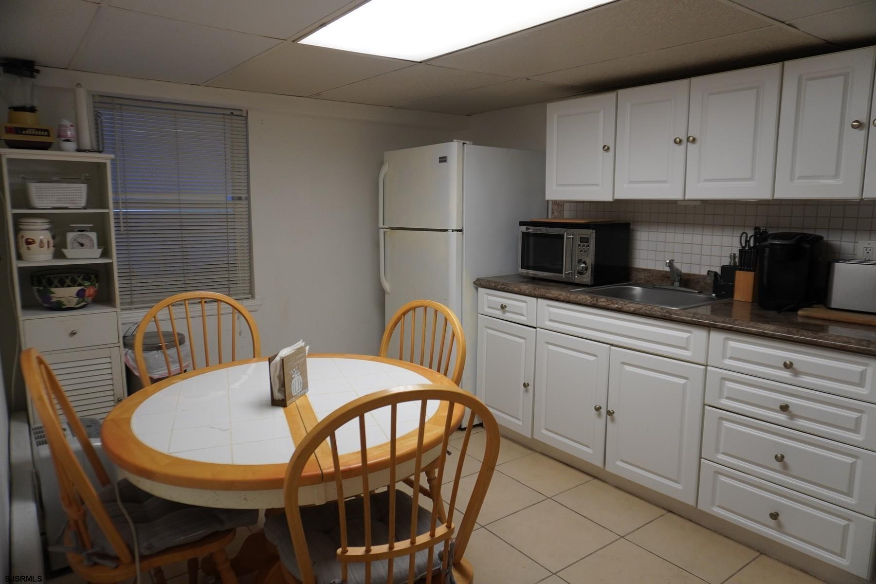 4703 Ventnor Avenue, Unit LOWER LEVEL Atlantic City, NJ 08401 - Photo 5 of 22 a kitchen with stainless steel appliances granite countertop a table and chairs