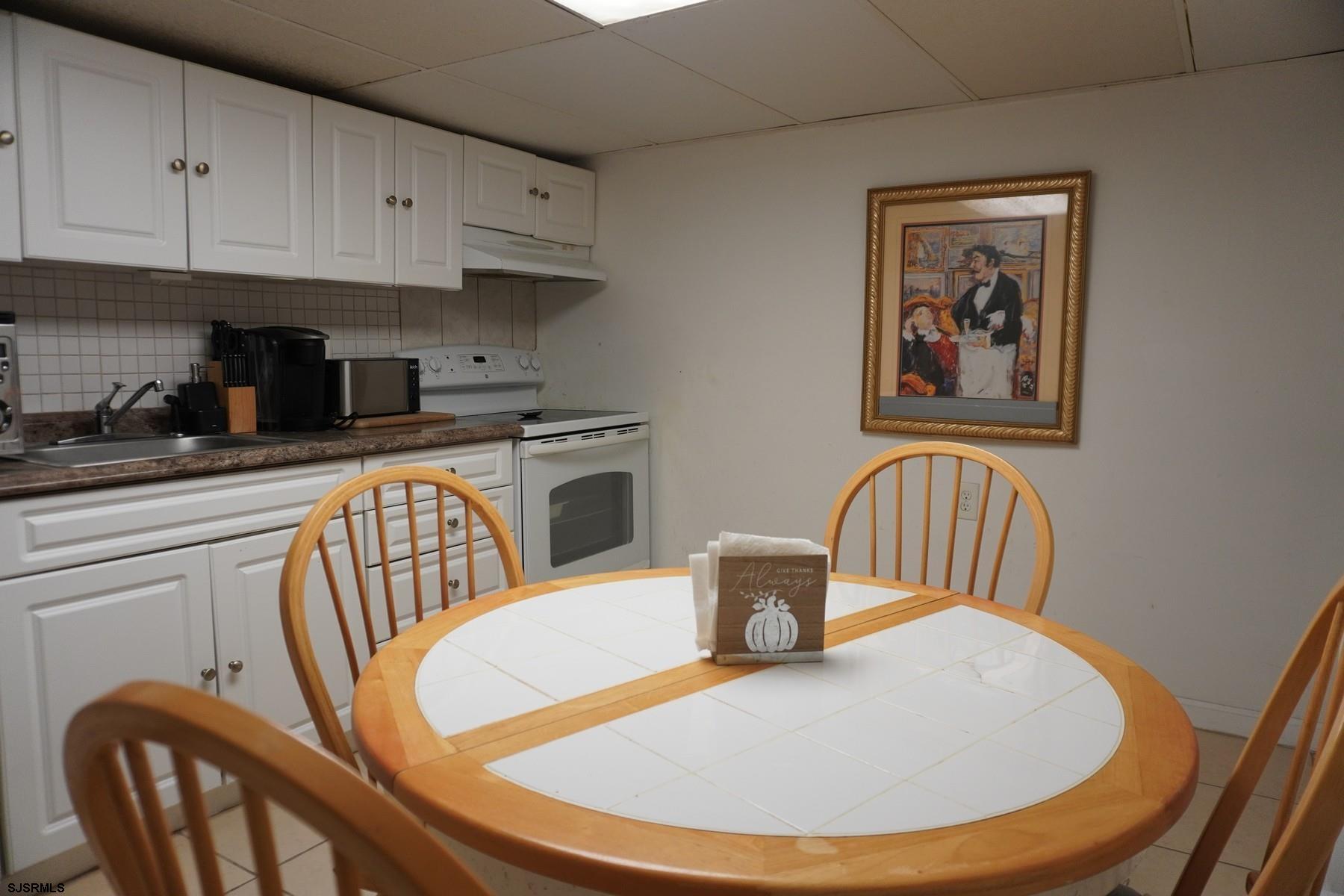 4703 Ventnor Avenue, Unit LOWER LEVEL Atlantic City, NJ 08401 - Photo 7 of 22 a kitchen with stainless steel appliances granite countertop a dining table and chairs