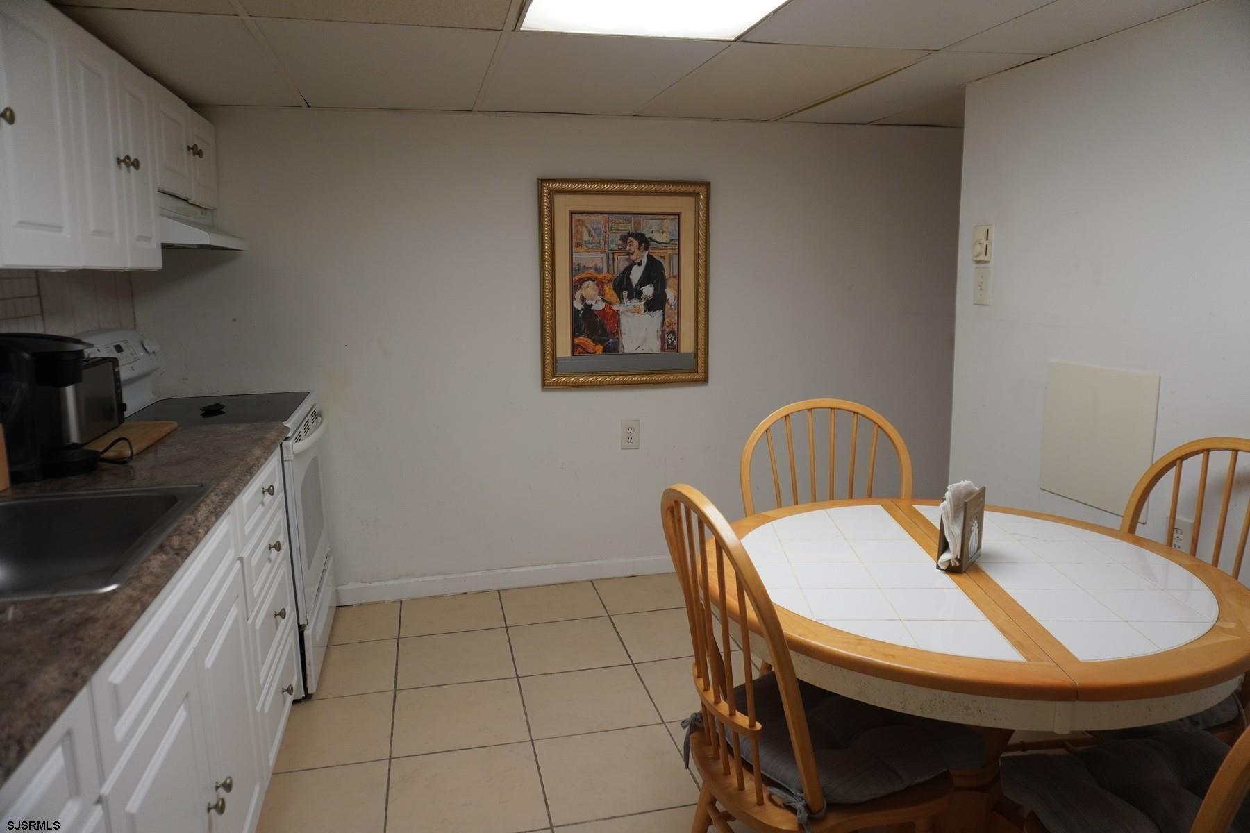 4703 Ventnor Avenue, Unit LOWER LEVEL Atlantic City, NJ 08401 - Photo 8 of 22 a view of a kitchen with a table and chairs