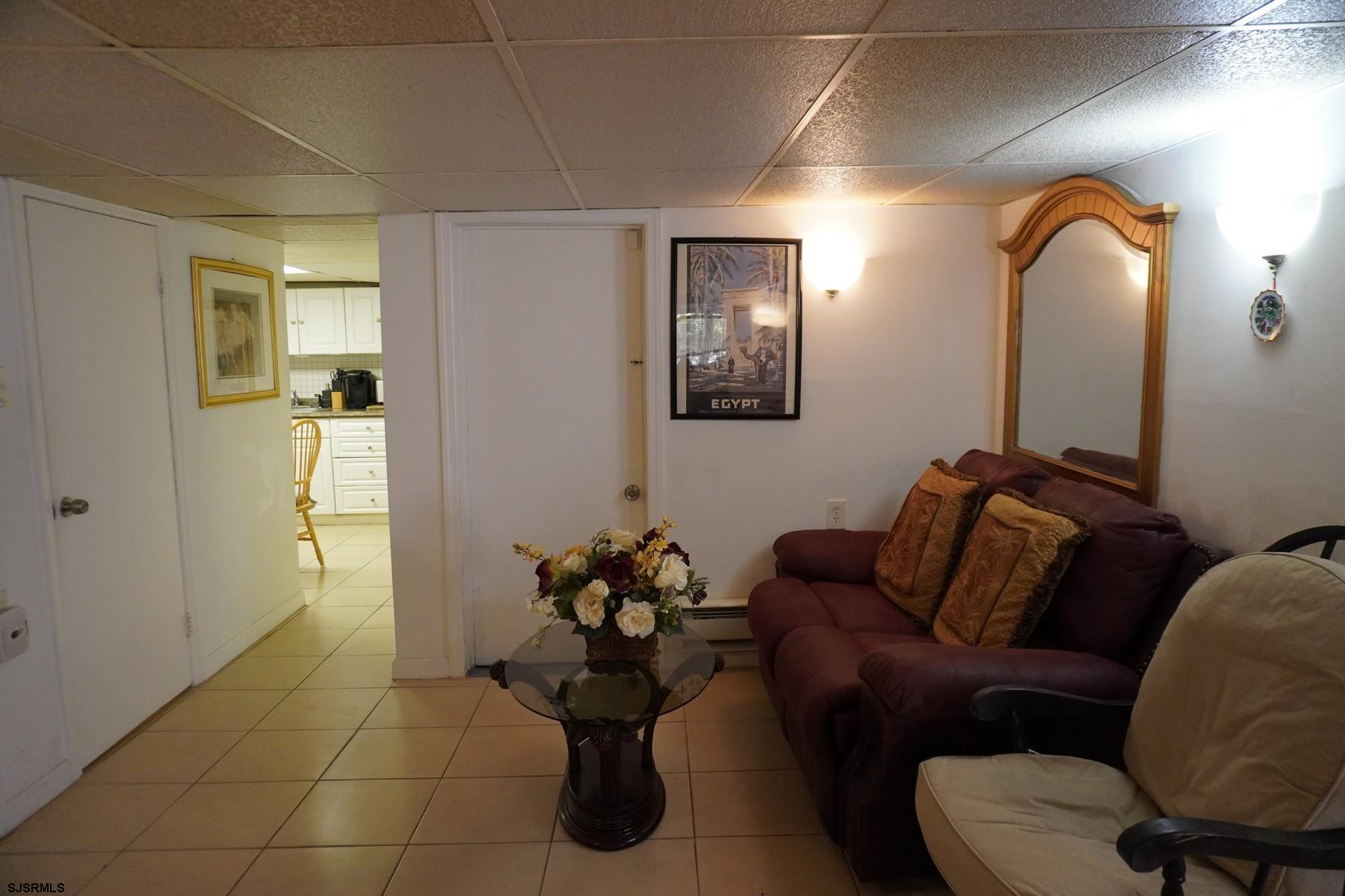 4703 Ventnor Avenue, Unit LOWER LEVEL Atlantic City, NJ 08401 - Photo 10 of 22 a living room with furniture and a mirror