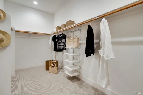 a view of walk in closet with clothes and shoes
