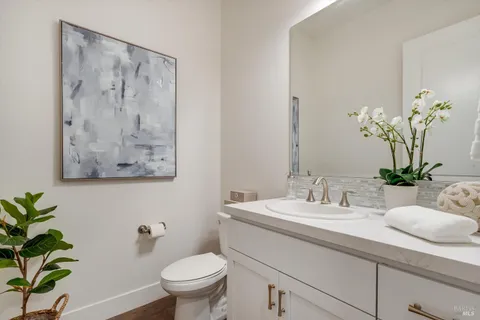 a bathroom with a sink a toilet and a large mirror