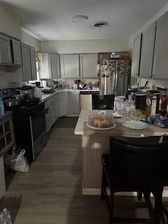 a kitchen with kitchen island granite countertop a sink cabinets and wooden floor
