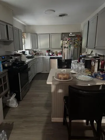 a kitchen with kitchen island granite countertop a sink cabinets and wooden floor