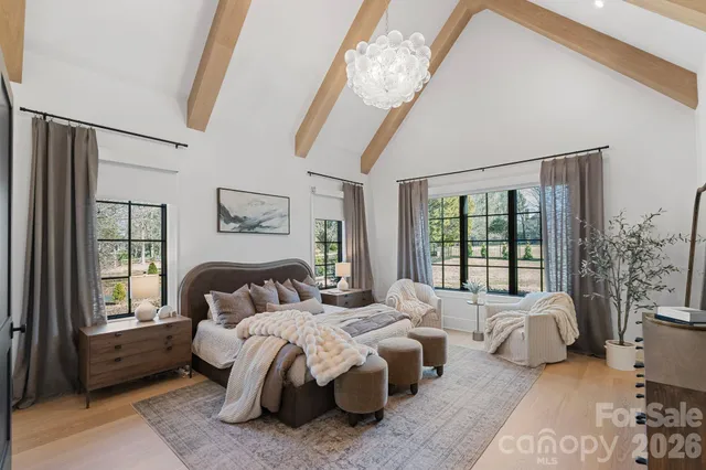 a bedroom with a bed couch and large windows