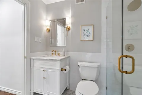 a bathroom with a toilet sink and mirror