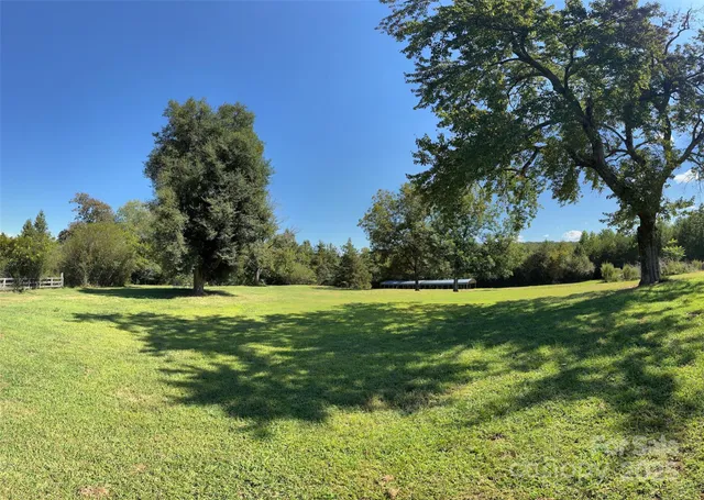 a view of a grassy field with trees