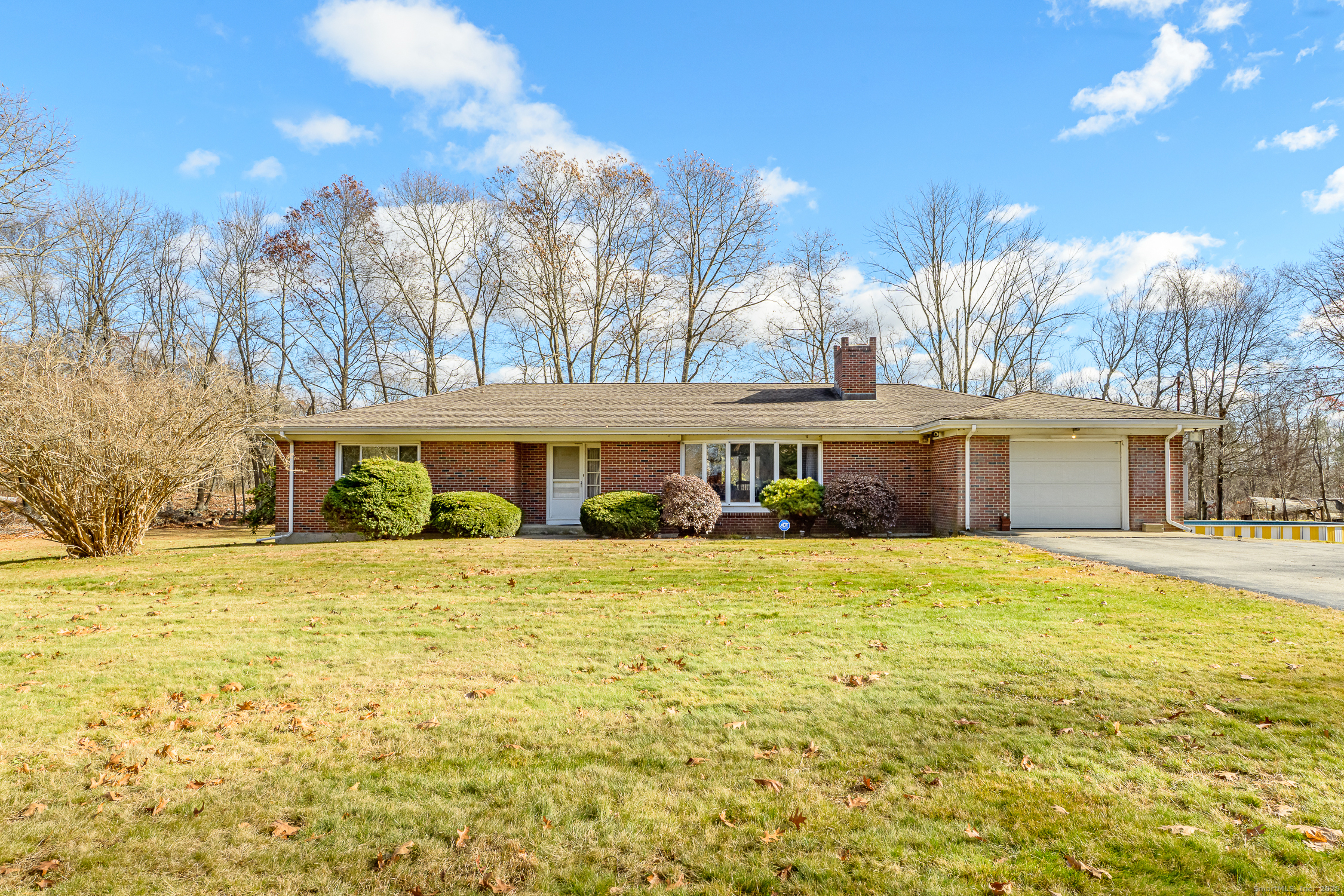 a front view of a house with a yard and trees