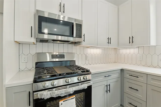 a kitchen with stainless steel appliances a stove a microwave and cabinets
