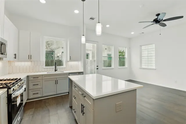 a kitchen with a stove sink and cabinets