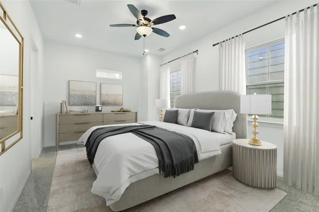a spacious bedroom with a bed a window and a ceiling fan