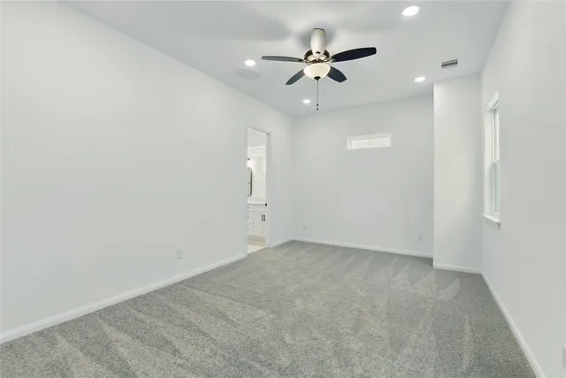 an empty room with a ceiling fan and a fan