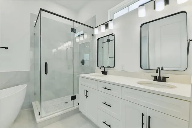 a bathroom with a double vanity sink mirror double and shower
