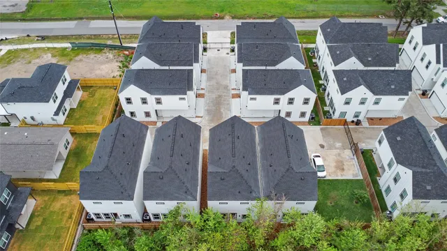 an aerial view of residential houses with outdoor space and parking