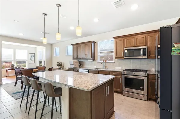a kitchen with a stove a sink and a refrigerator