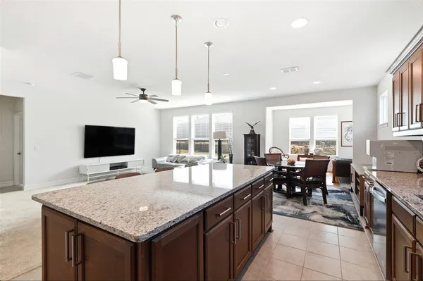 a large kitchen with kitchen island a large counter space and stainless steel appliances