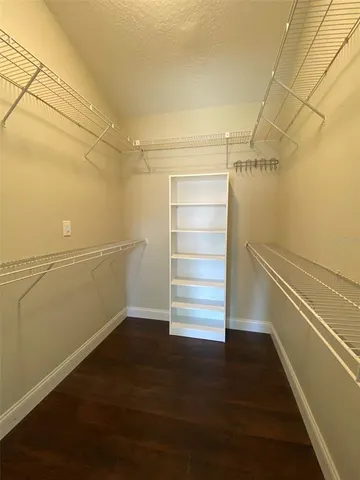 a view of walk in closet with empty racks
