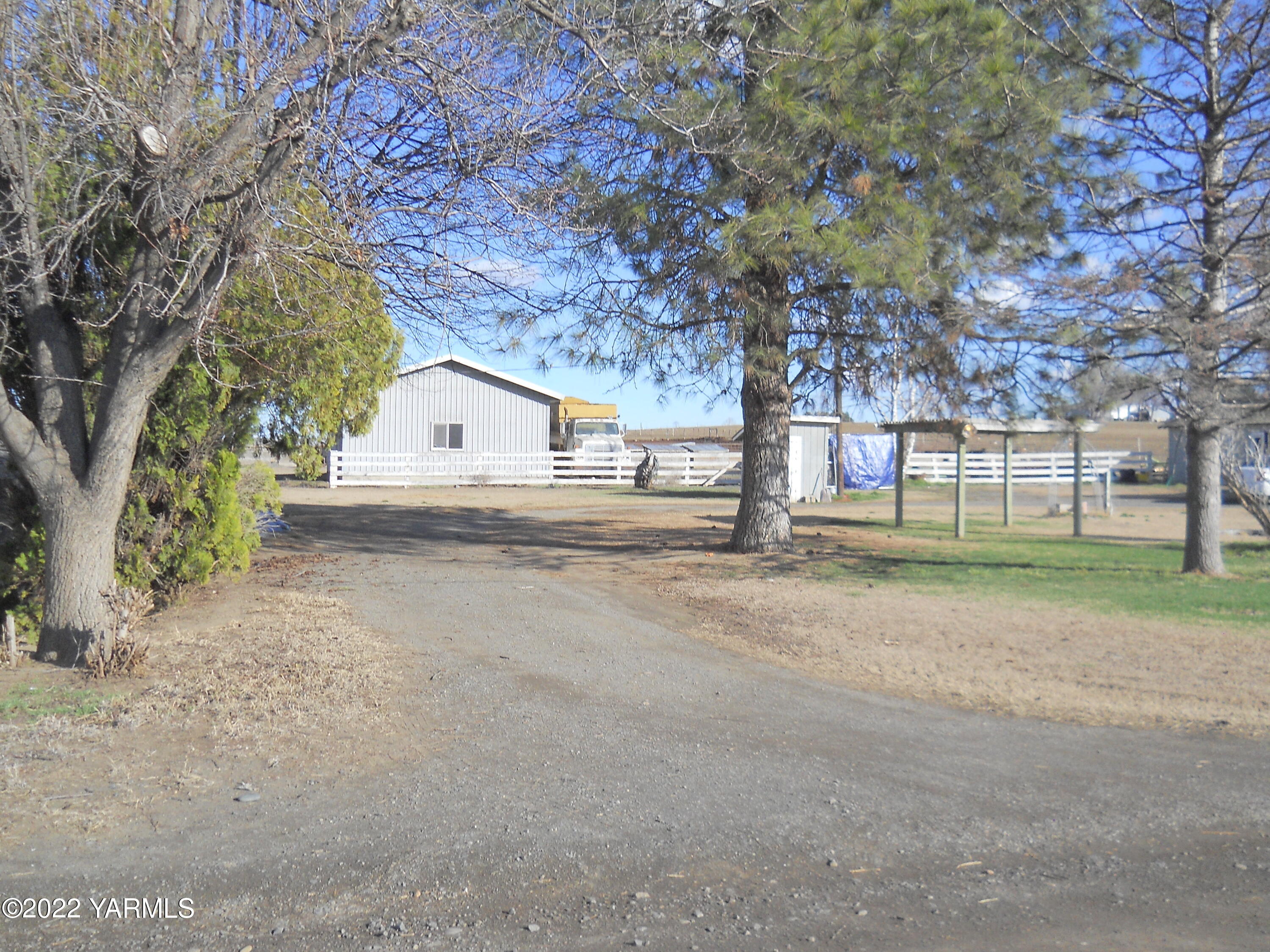 601 Den Boer Road Grandview, WA 98930 - Photo 9 of 10 a view of white house with a big yard and large trees