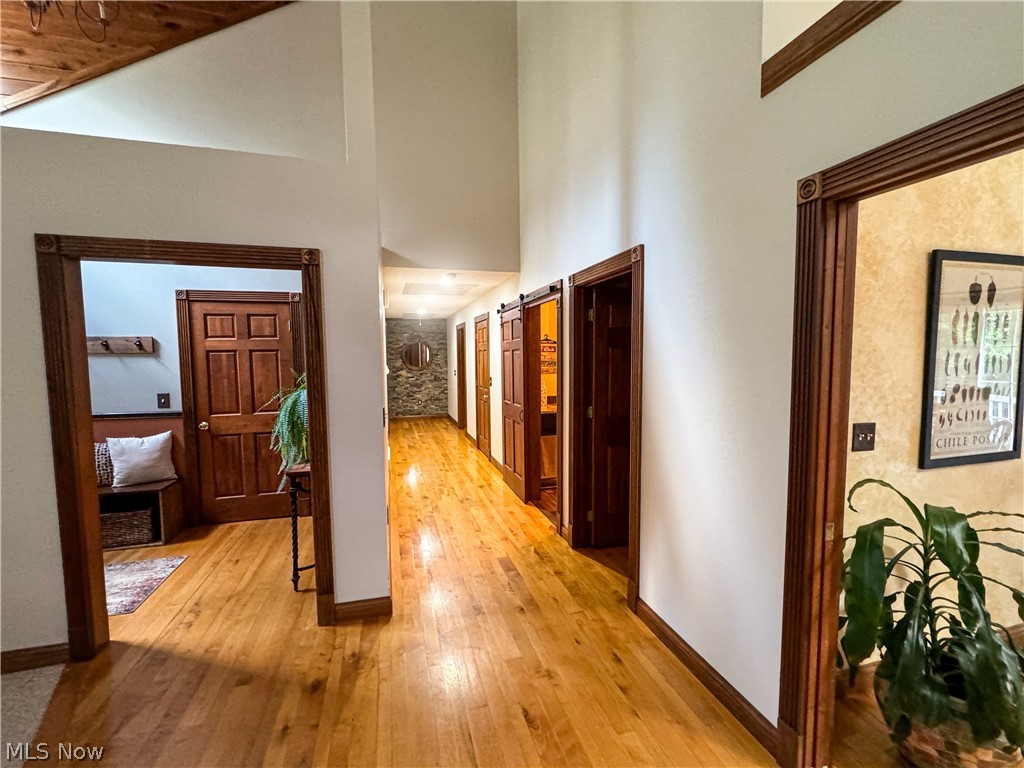 2002 Laurel Ridge Road Culloden, WV 25510 - Photo 13 of 36 Corridor featuring a barn door, light wood-type flooring, and a towering ceiling