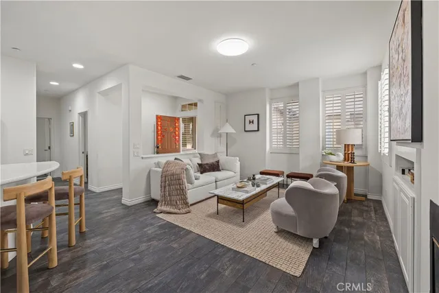 a living room with furniture a large window and wooden floor