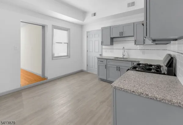 a kitchen with granite countertop a sink stove and cabinets