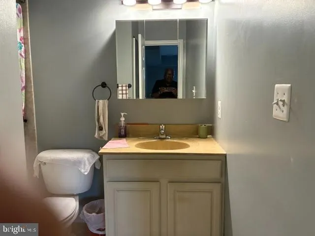 a bathroom with a toilet sink and mirror