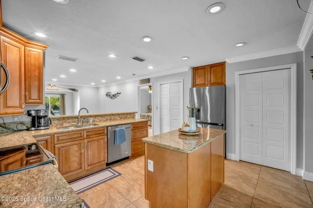 a kitchen with stainless steel appliances granite countertop a sink and a refrigerator