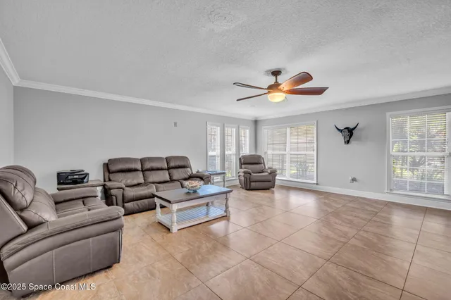 a living room with furniture and a large window with garden view
