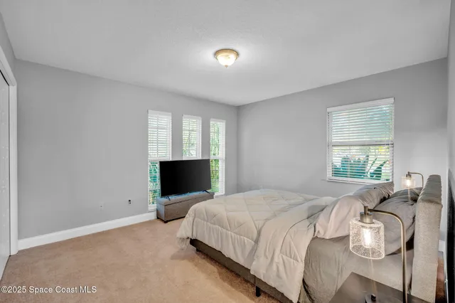a bedroom with a bed and flat screen tv