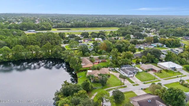 an aerial view of residential houses with outdoor space and trees