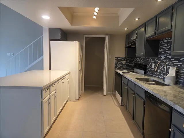 a kitchen with stainless steel appliances granite countertop a sink a stove and a refrigerator
