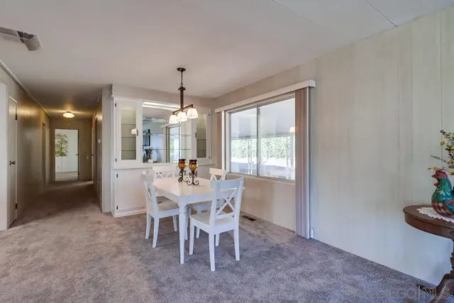 a view of a dining room with furniture large windows and wooden floor