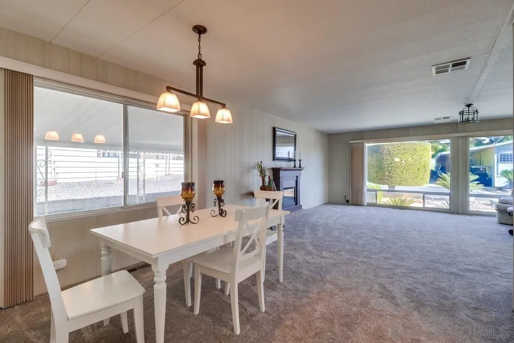 18218 Paradise Mountain Road, Unit 129 Valley Center, CA 92082 - Photo 15 of 58 a view of a dining room with furniture large windows and wooden floor
