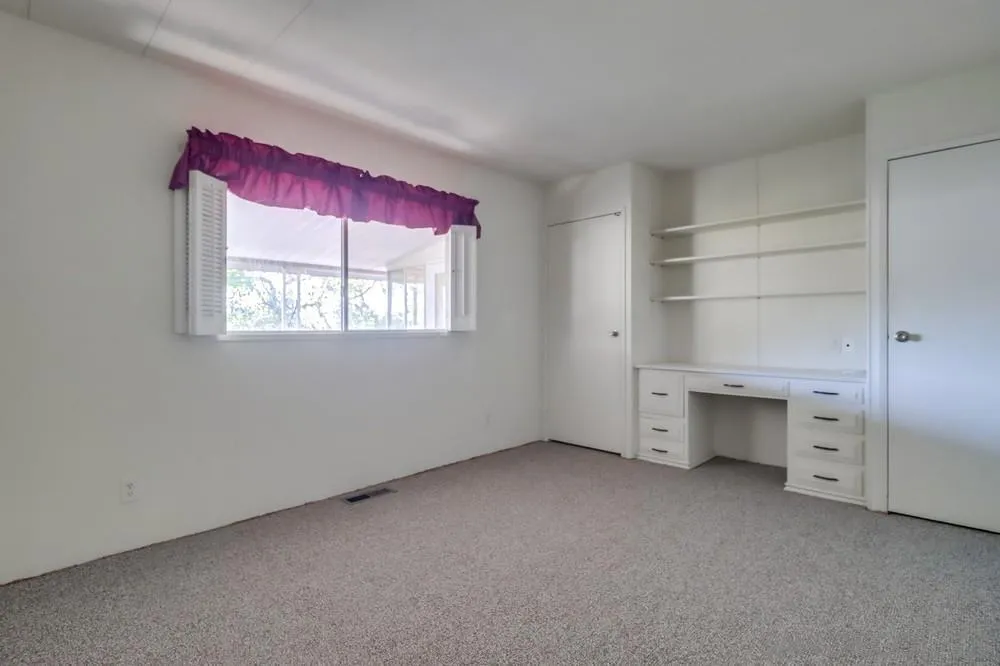 18218 Paradise Mountain Road, Unit 129 Valley Center, CA 92082 - Photo 23 of 58 an empty room with a fireplace and window