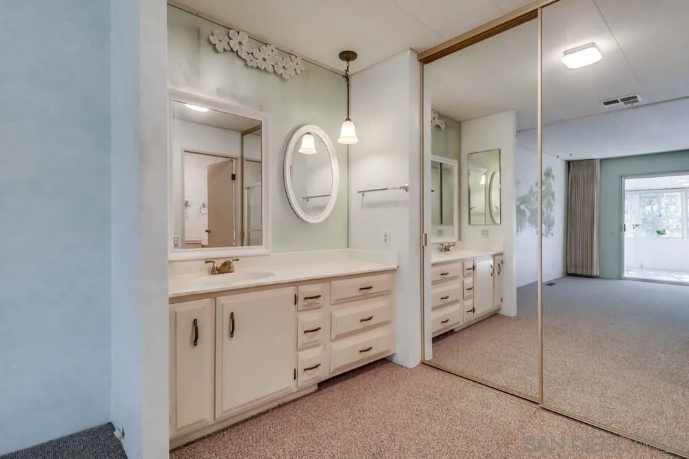 18218 Paradise Mountain Road, Unit 129 Valley Center, CA 92082 - Photo 29 of 58 a spacious bathroom with a double vanity sink and a mirror