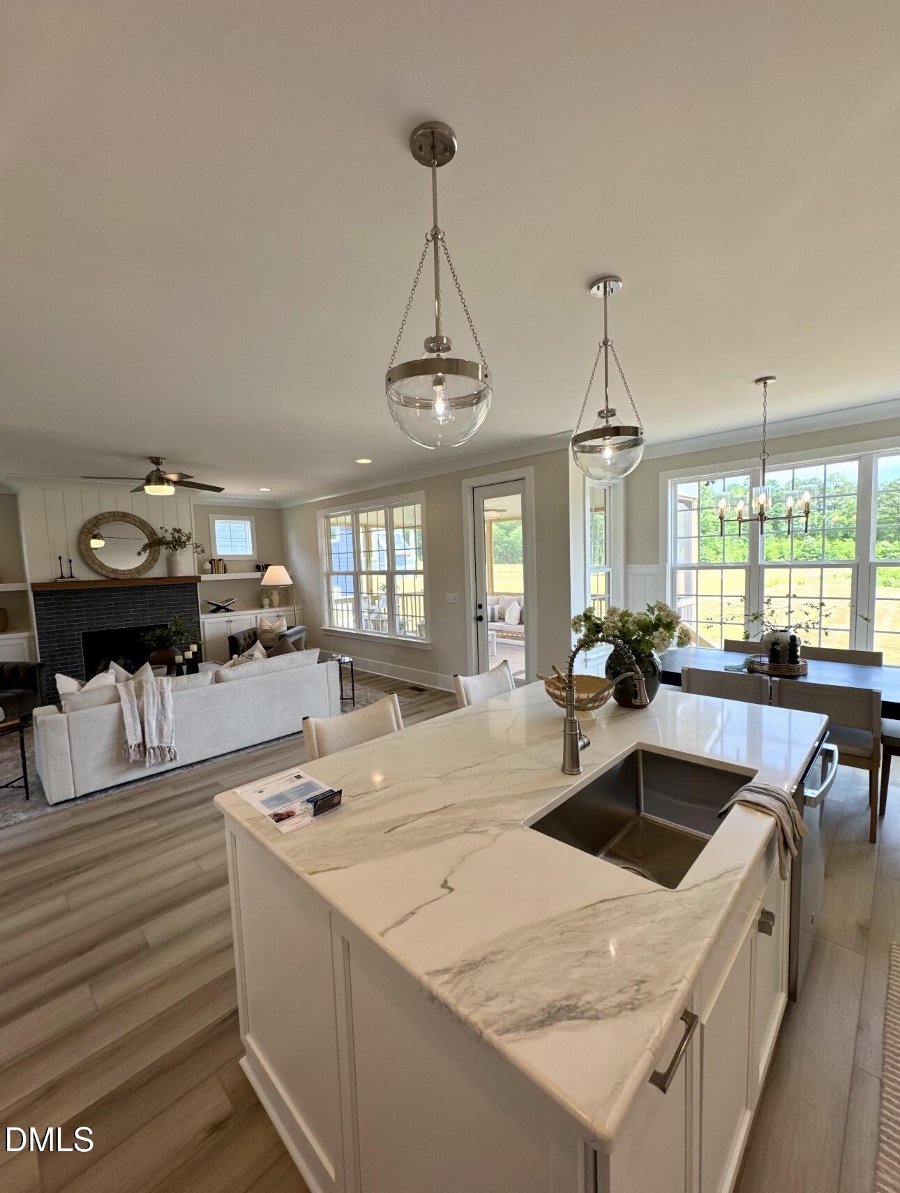 1057 Azalea Garden Circle Raleigh, NC 27603 - Photo 14 of 20 a kitchen with a stove a kitchen island a sink dishwasher a dining table and chairs with wooden floor