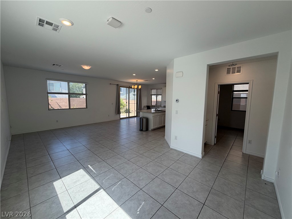 3228 Azalea Ridge Court Henderson, NV 89052 - Photo 28 of 28 An open floorplan with tiled flooring connects the living area to a modern kitchen.